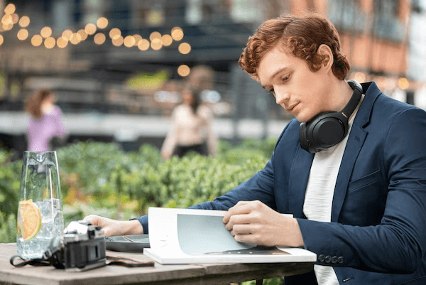 Tai nghe WH-1000XM4 được đeo trên cổ trong quán cà phê