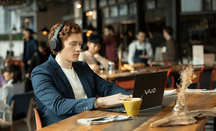 Người đàn ông đeo WH-1000XM4 trong nhà hàng